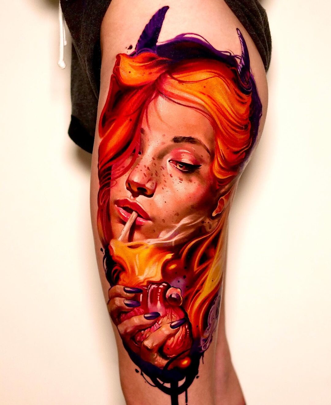 Color realism tattoo of a red-haired woman with devil horns on the arm