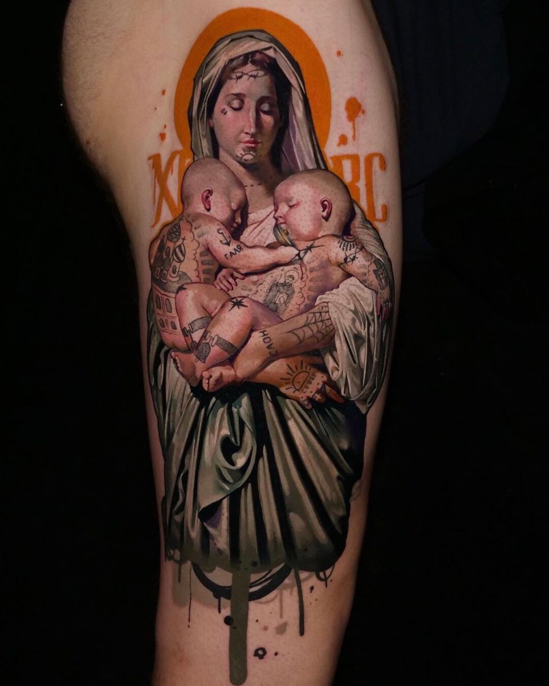 Color realism religious tattoo of the Madonna and child on the thigh